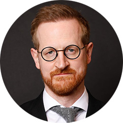 Mann mit roten Haaren, Bart und Brille
