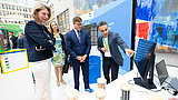 Mann deutet auf Bildschirm, Carsten Schneider und Helena Melnikov schauen zu