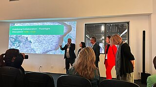 5 Personen halten Präsentation mit dem Titel "Mobilizing Collaboration - Flashlight Discussion"