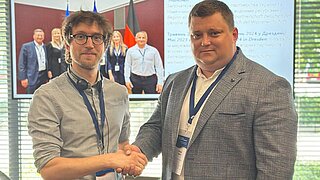 Robin Dietsch (BAV) und Oleksandr Kotenko (EcoService-2022) geben sich bei der Kommunalen Partnerschaftskonferenz 2025 in Münster die Hand.