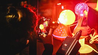 Frau fotografiert mit Handy ausgestellte Lampen