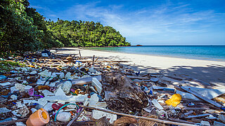 Plastikmüll liegt an einem idyllischen Strand in Thailand
