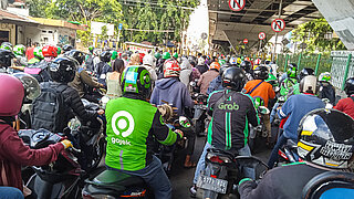 Menschen auf Motorrollern im Stau