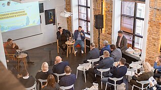 Mehrere Personen sitzen auf einer Konferenz.