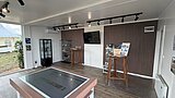 Moderner Ausstellungsraum mit großem interaktivem Tisch, Stehtischen, Monitor an der Wand und Informationsmaterial