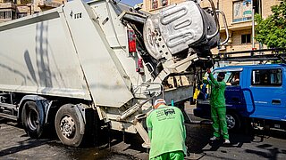 ein Müllwagen wird von 2 Personen in Jordanien bedient