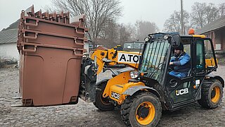 Gabelstabler transportiert große braune Tonnen