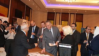 Der jordanische Umweltminister und weitere Teilnehmende informieren sich an einem Stand