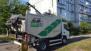 Müllwagen fährt zu Wohnblock