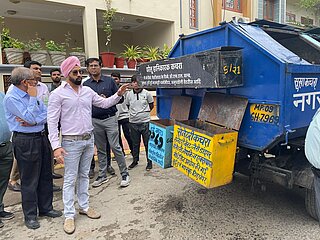 Männer vor Recyclingsystem