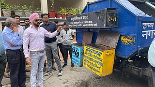 Teilnehmende besichtigen eine Haus-zu-Haus Sammlungsstelle von festen Abfällen, welche durch die kommunale Müllabfuhr in Indore verwaltet wird
