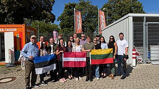 Reisegruppe hält baltische Flaggen in der Hand