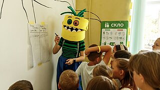 Maskottchen erklärt etwas