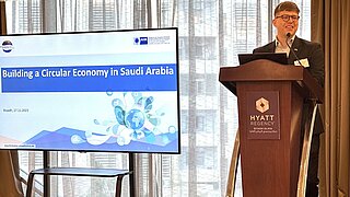 Robert Gehrke steht auf einem Podium und präsentiert "Building a Circular Economy in Saudia Arabia"